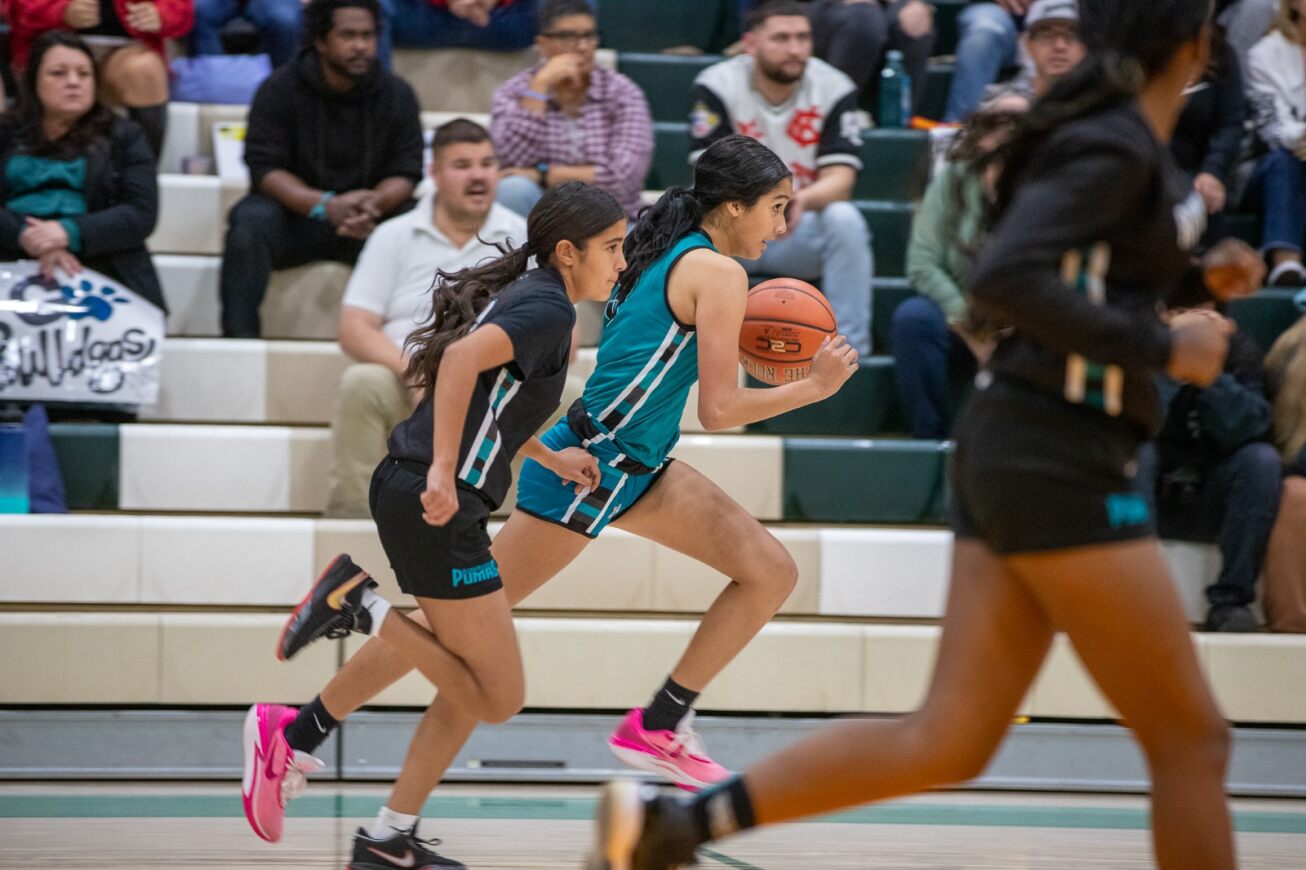 A Dodge player runs down the court with the ball