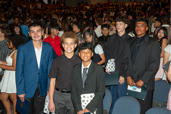 Students smile in the auditorium after the ceremony